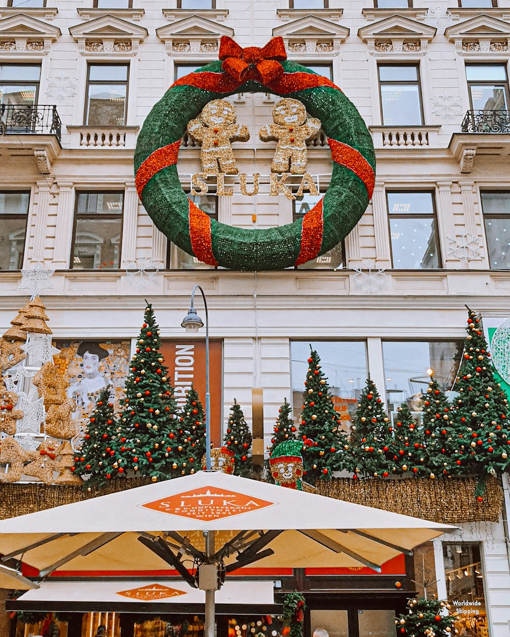 a large christmas wreath hanging on the side of a building