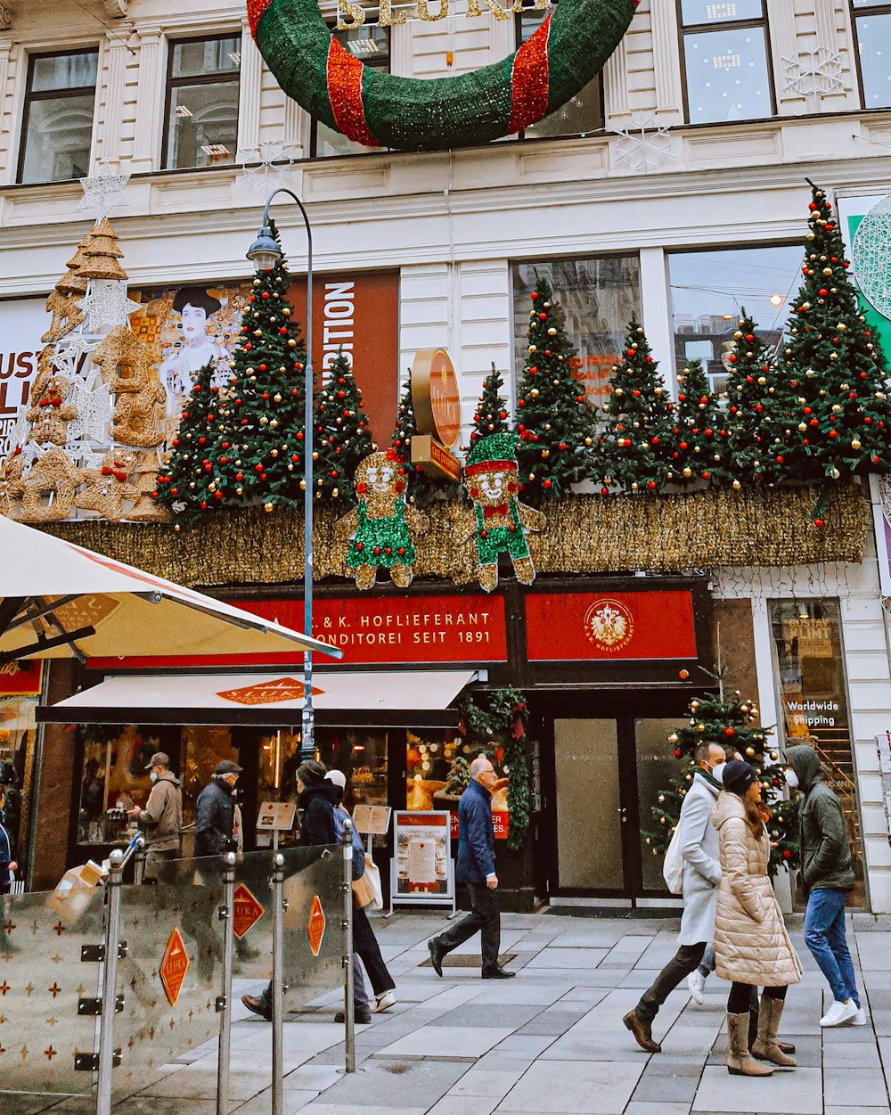 a group of people walking down a street in front of a building