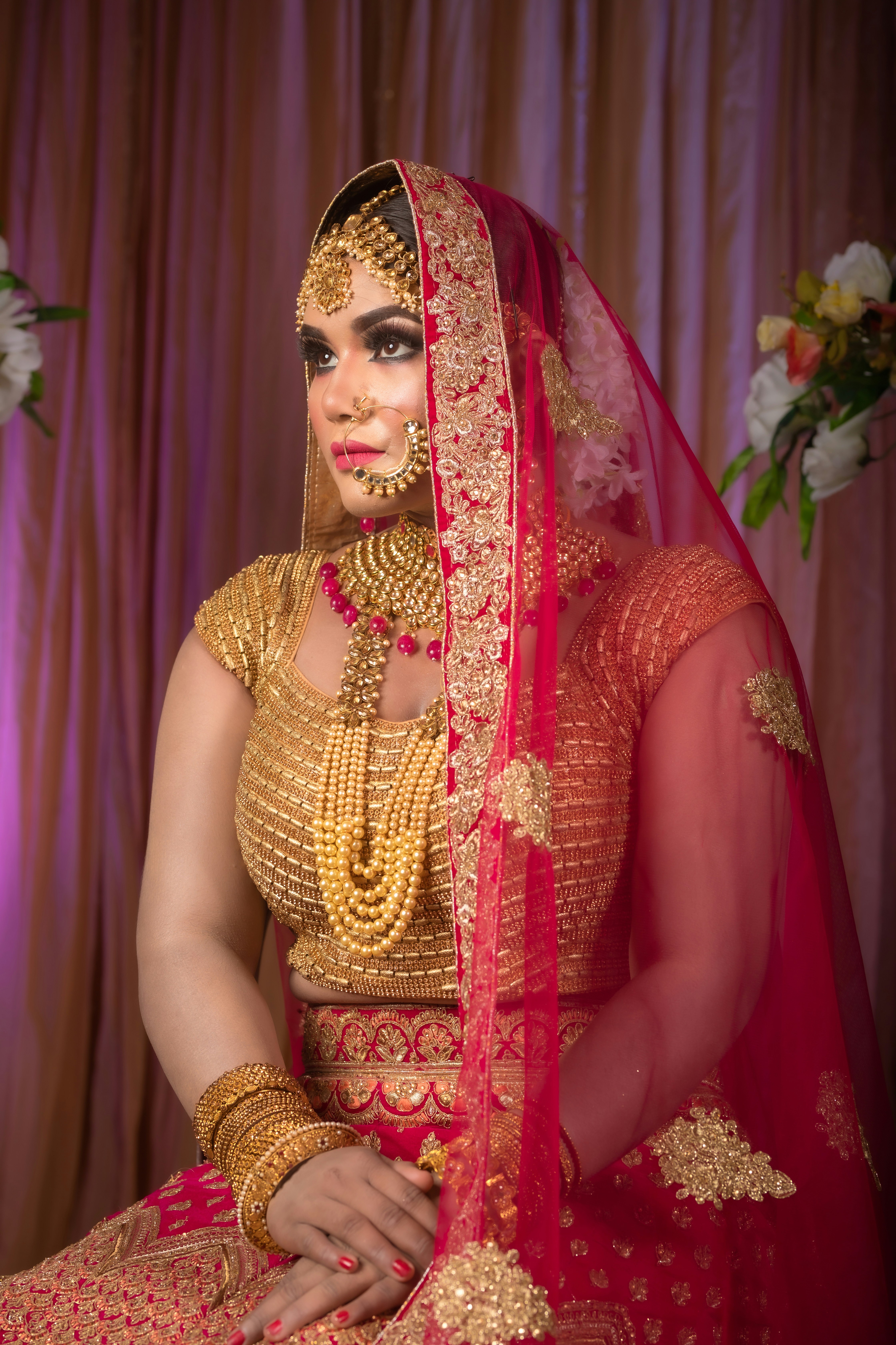 a woman in a red and gold wedding outfit