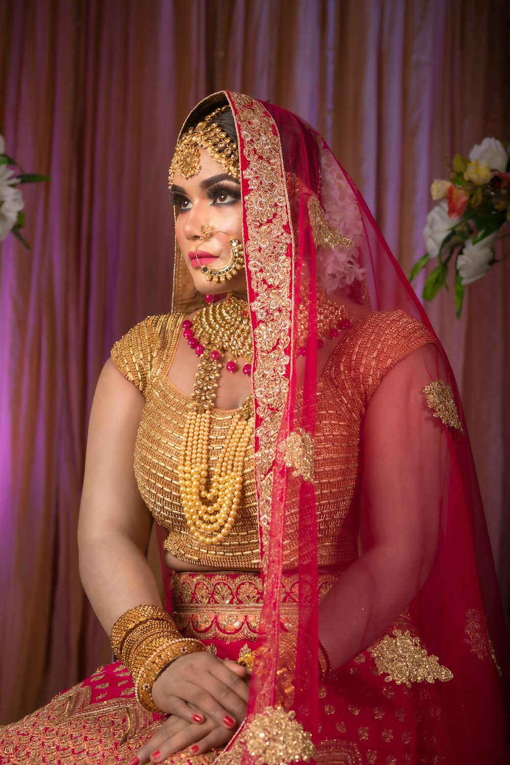 a woman in a red and gold wedding outfit