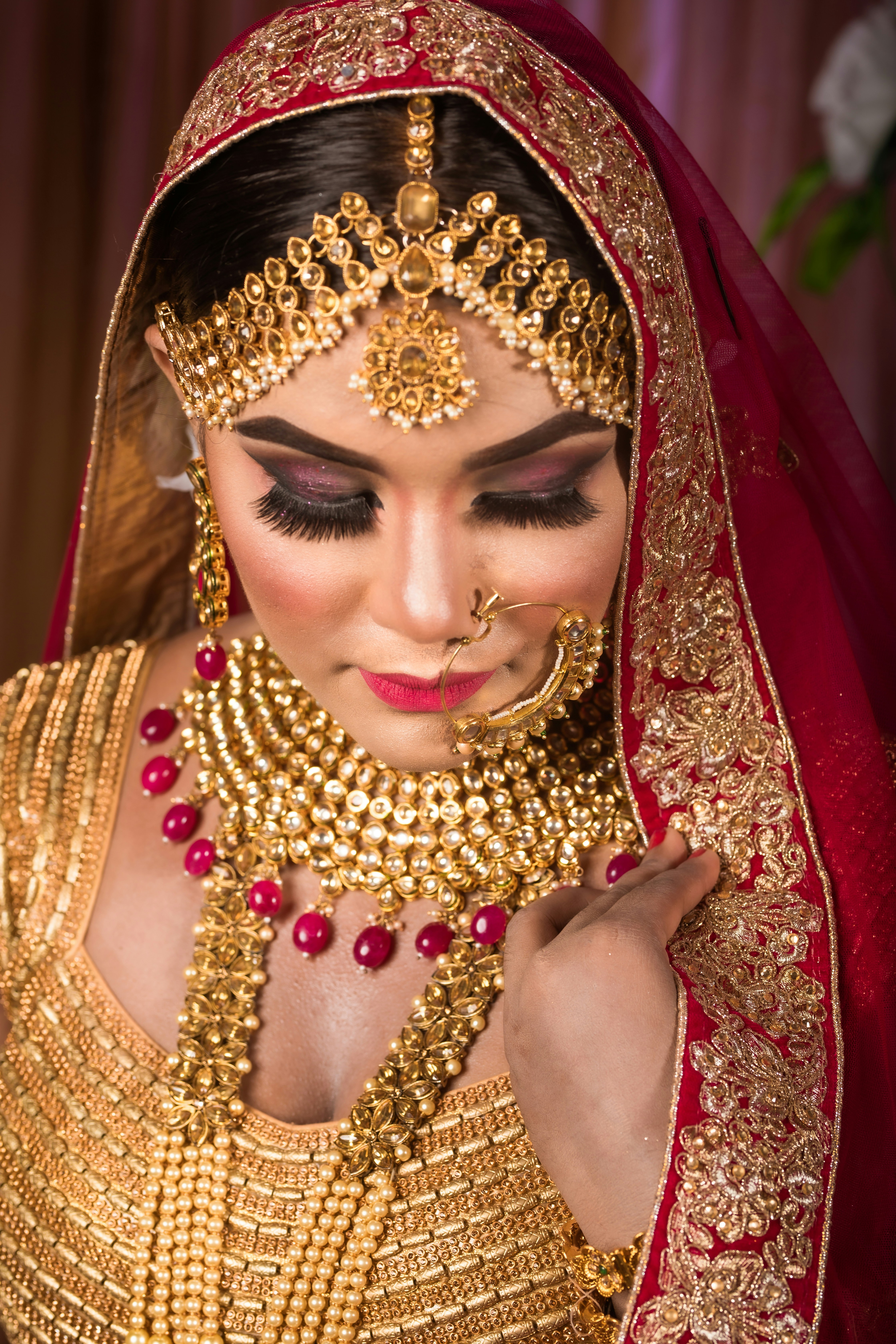 a woman wearing a gold and red bridal outfit