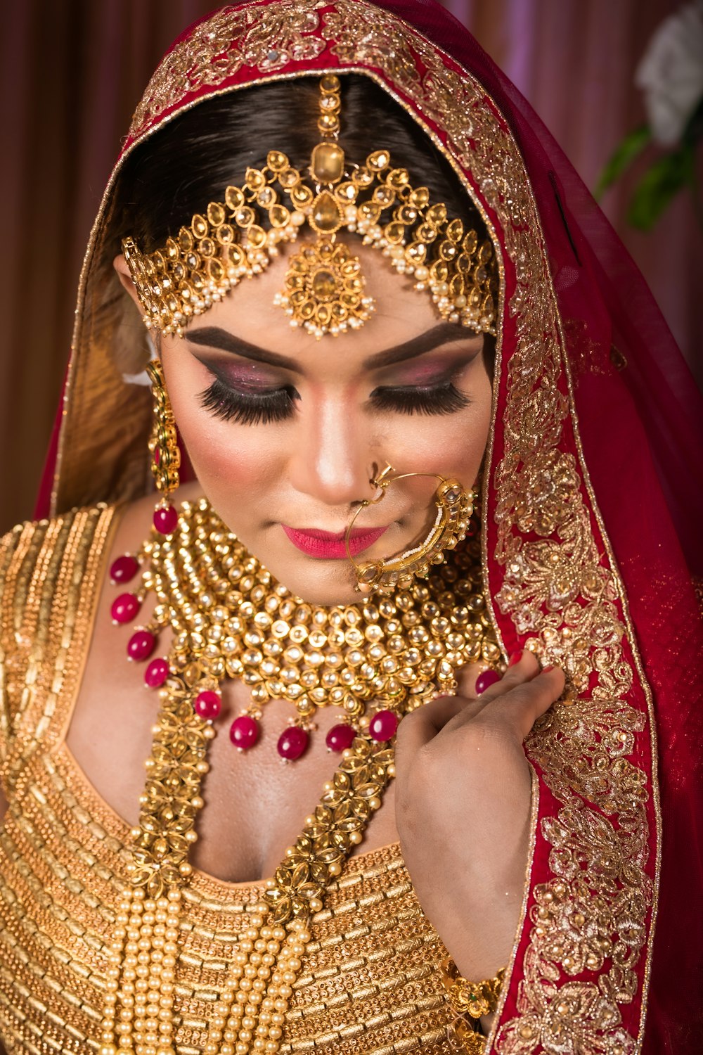 a woman wearing a gold and red bridal outfit