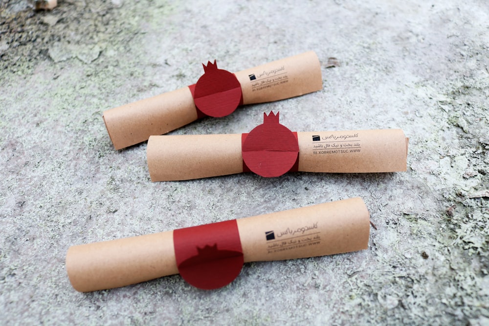 trois rouleaux de papier hygiénique avec du papier rouge dessus