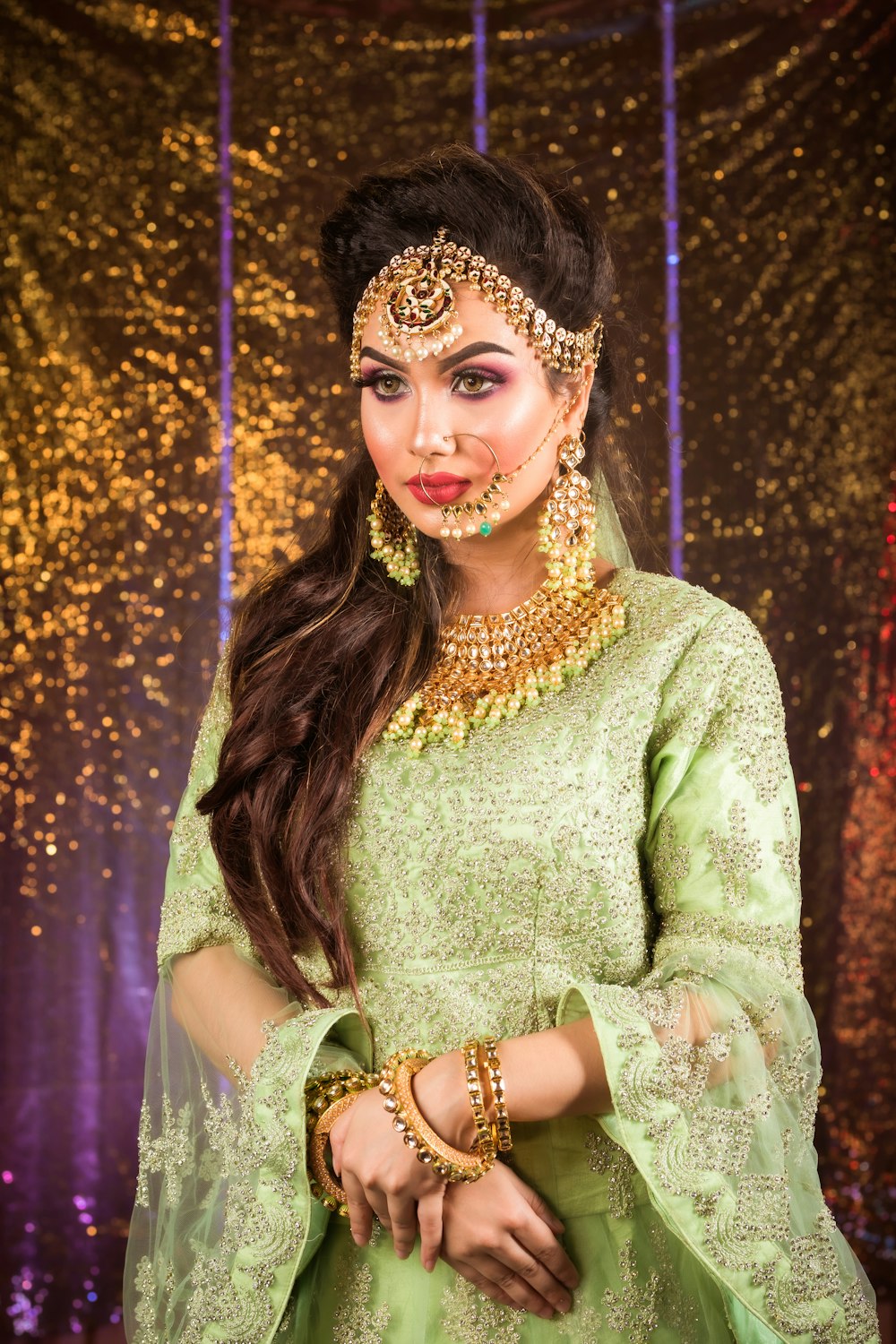 a woman wearing a green outfit and jewelry