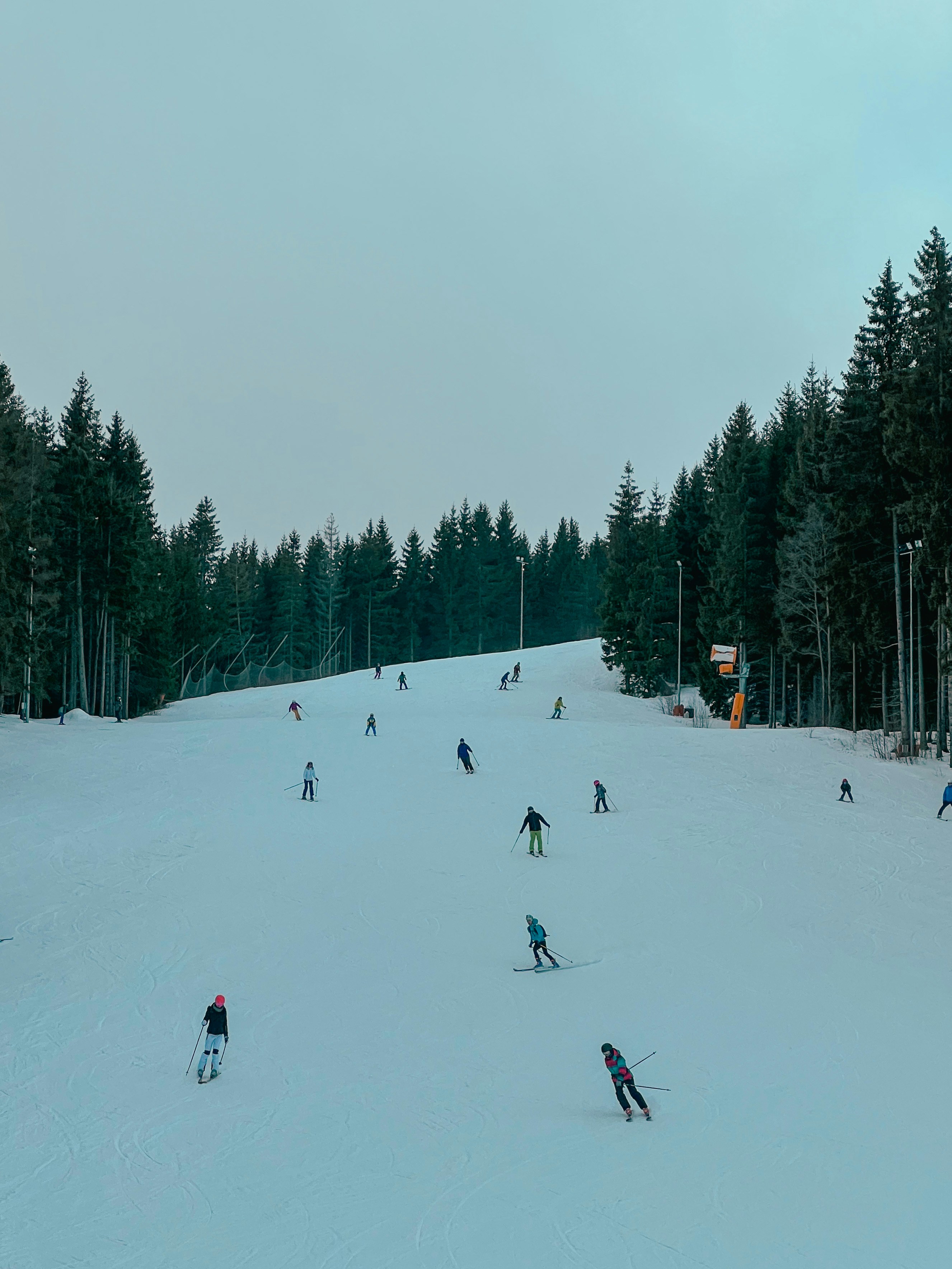 a group of people riding skis down a snow covered slope