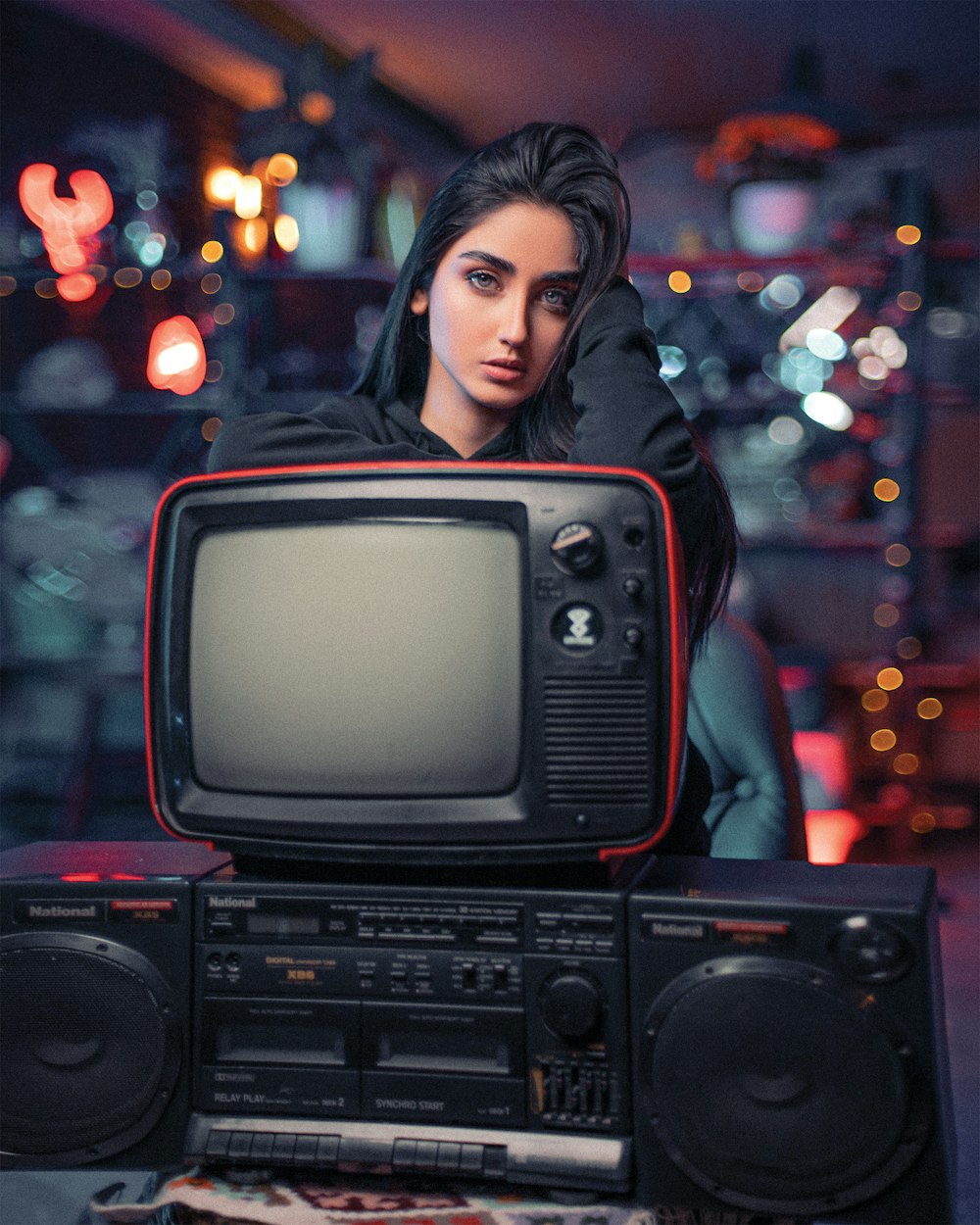 a woman sitting in front of an old tv