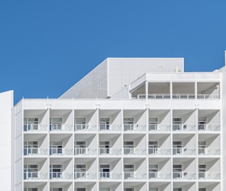 a tall white building with balconies and balconies