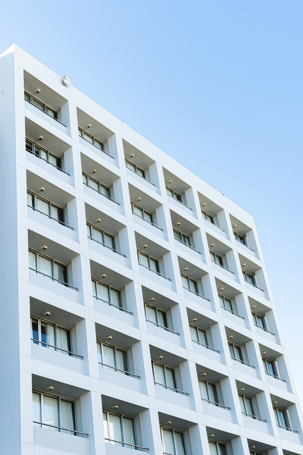 a tall white building with balconies and windows