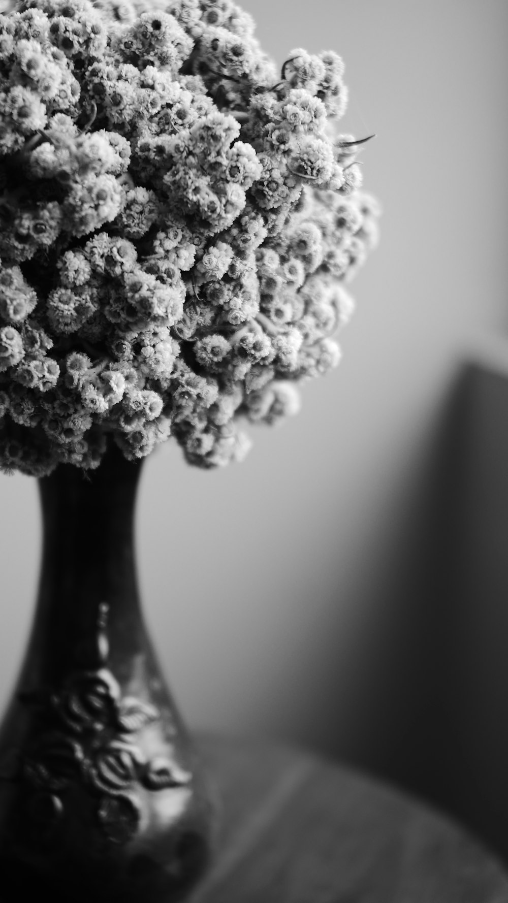 a black and white photo of a vase filled with flowers