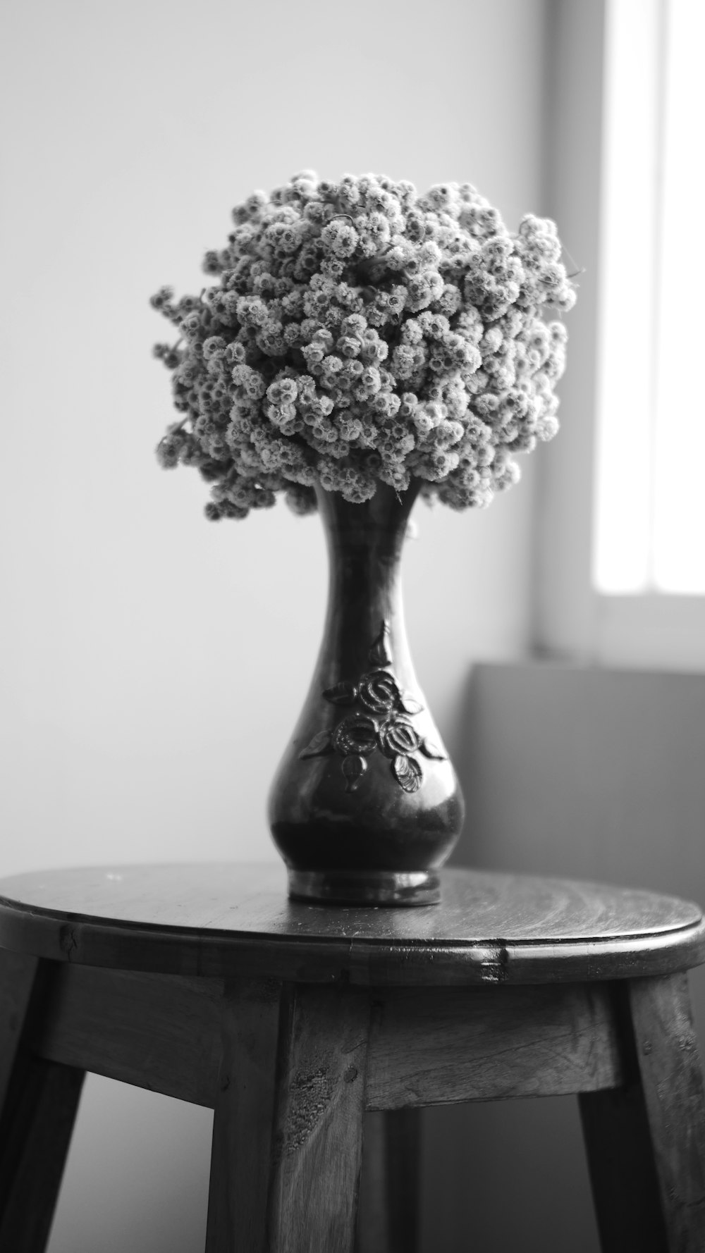 Une photo en noir et blanc d’un vase de fleurs