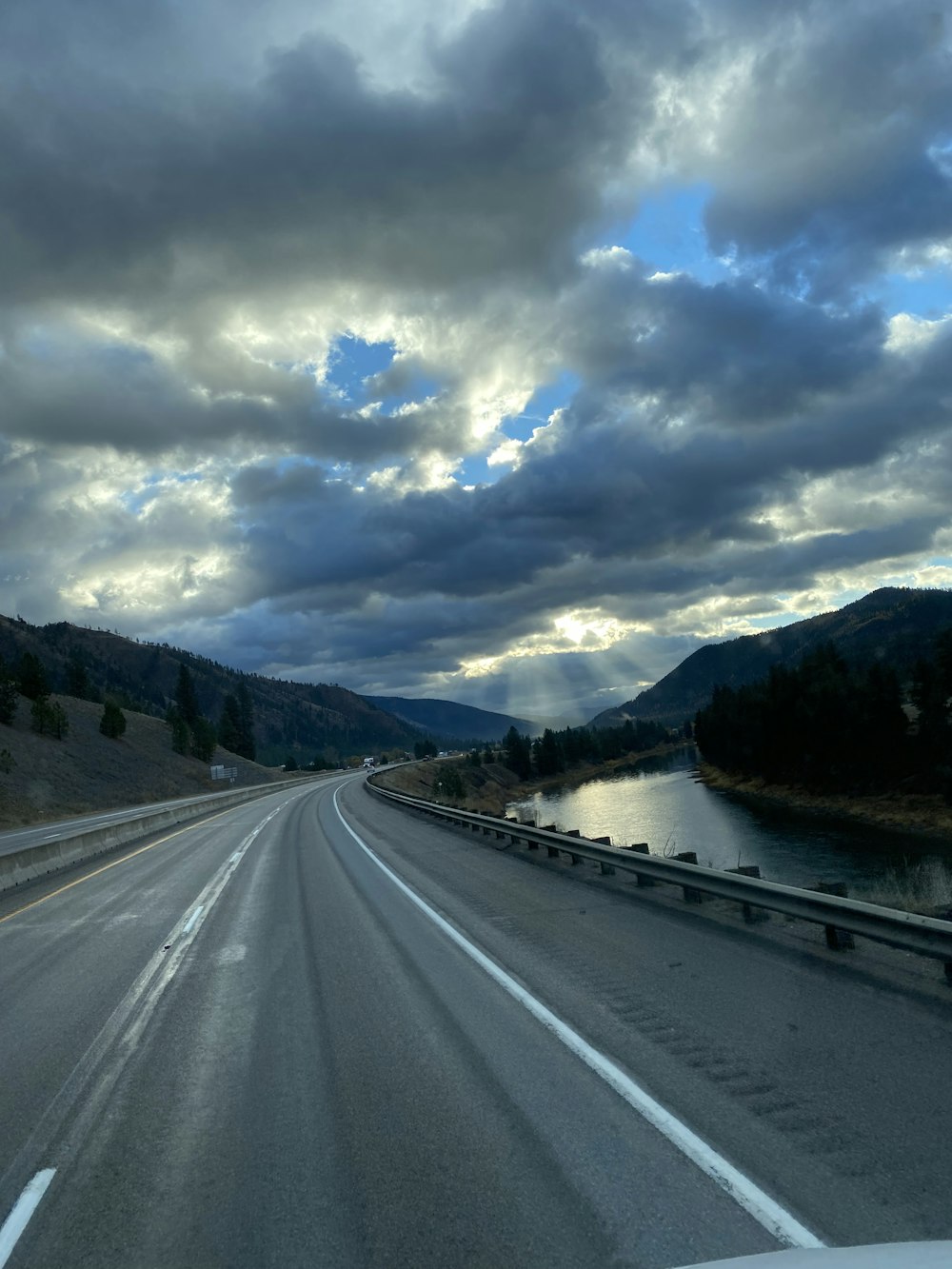 a car driving down a highway under a cloudy sky