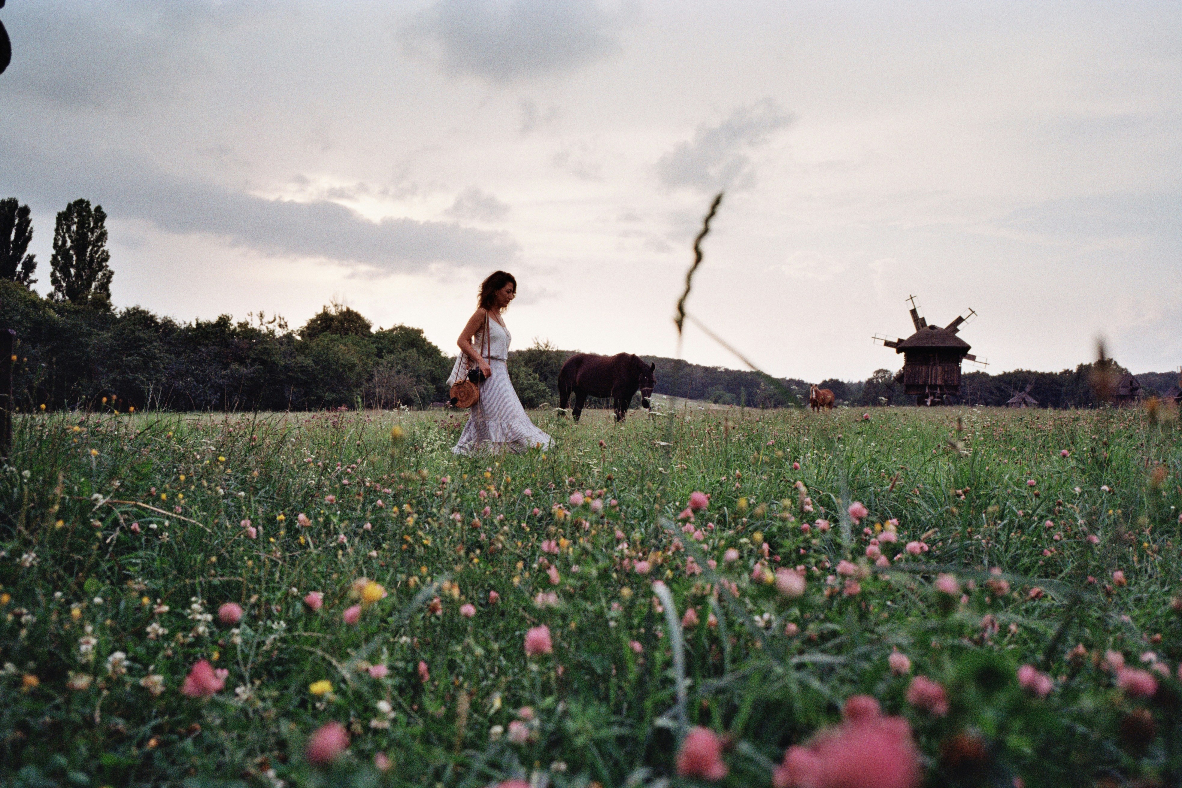 a group of people standing on top of a grass covered field