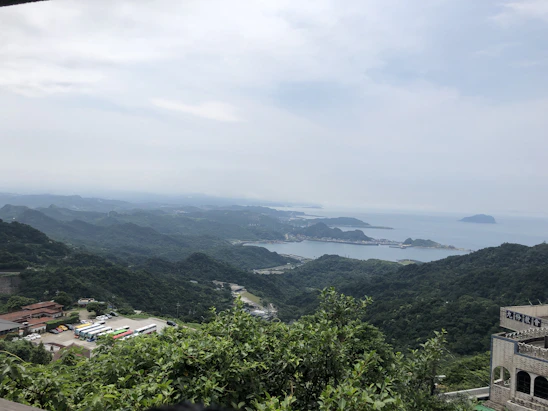 A welcoming driver assisting travelers onto a comfortable shuttle bus framed by scenic coastal views.