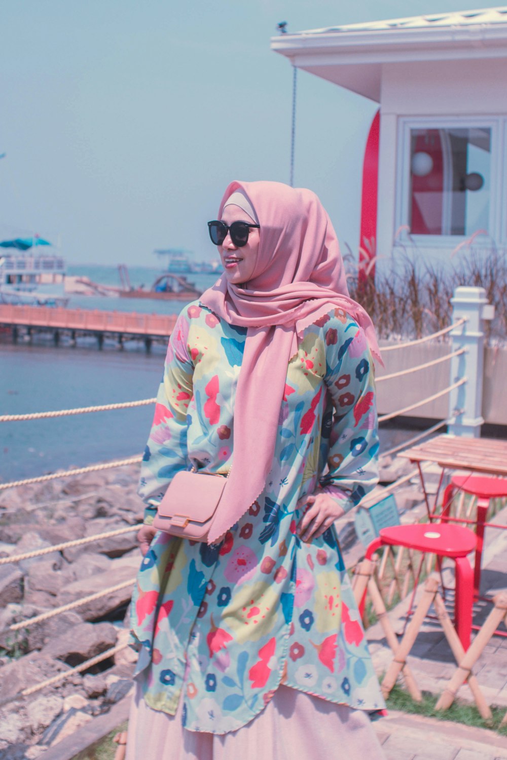 a woman in a colorful dress standing on a pier