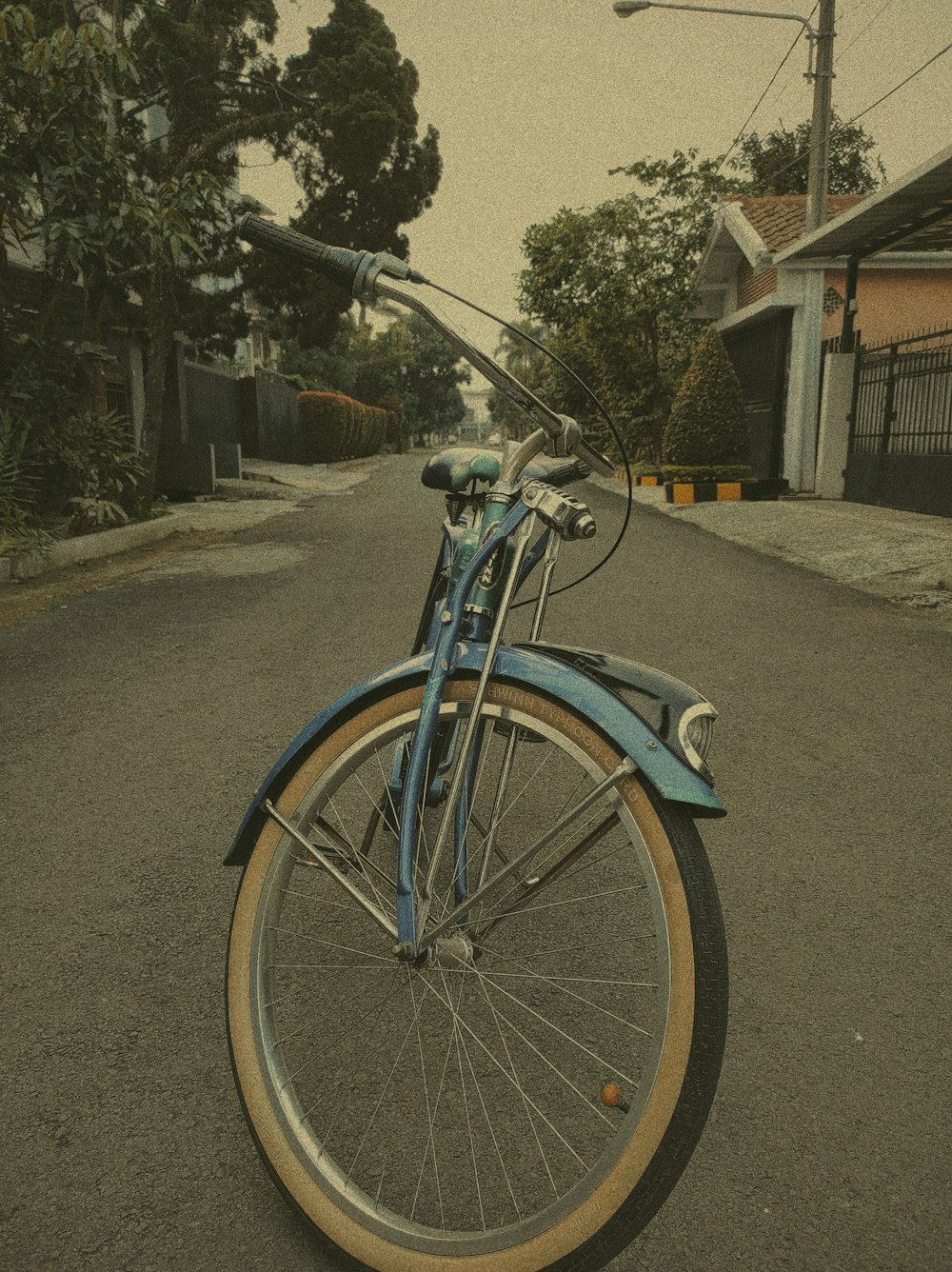 a blue bicycle parked on the side of a road