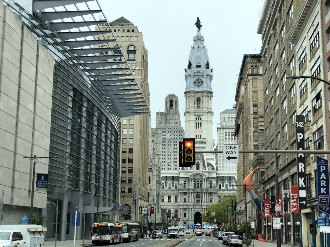 a traffic light on a city street with tall buildings in the background, Downtown Philly