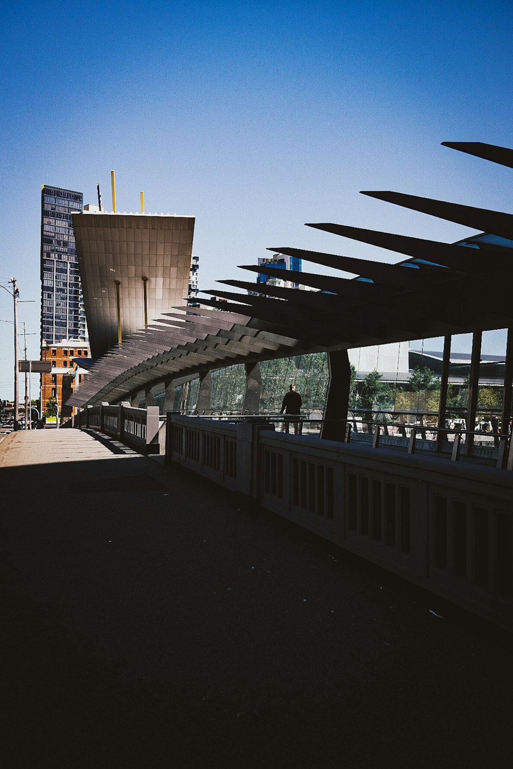 a person walking across a bridge near a tall building
