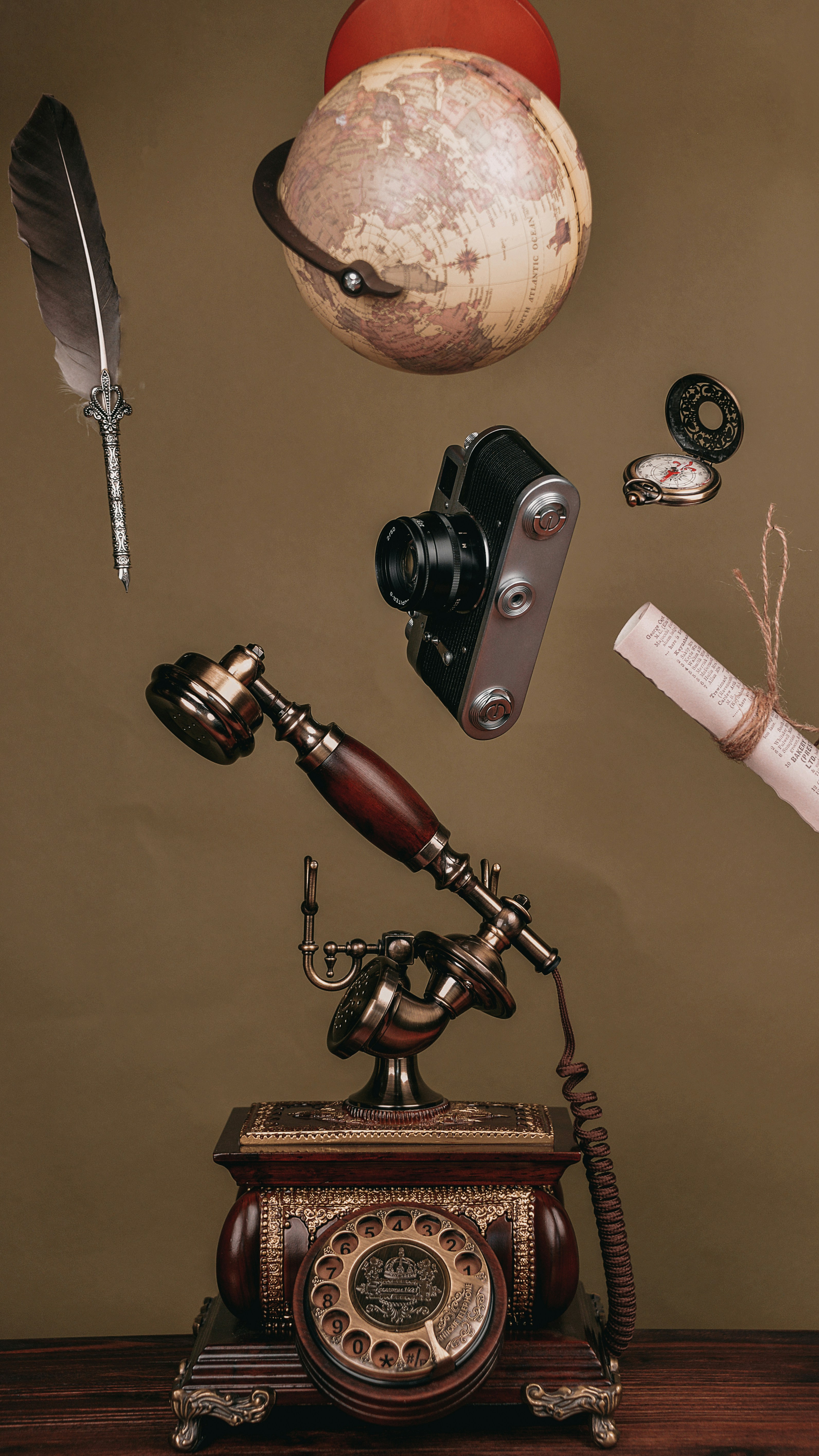 an old fashioned phone with a telescope and other items above it