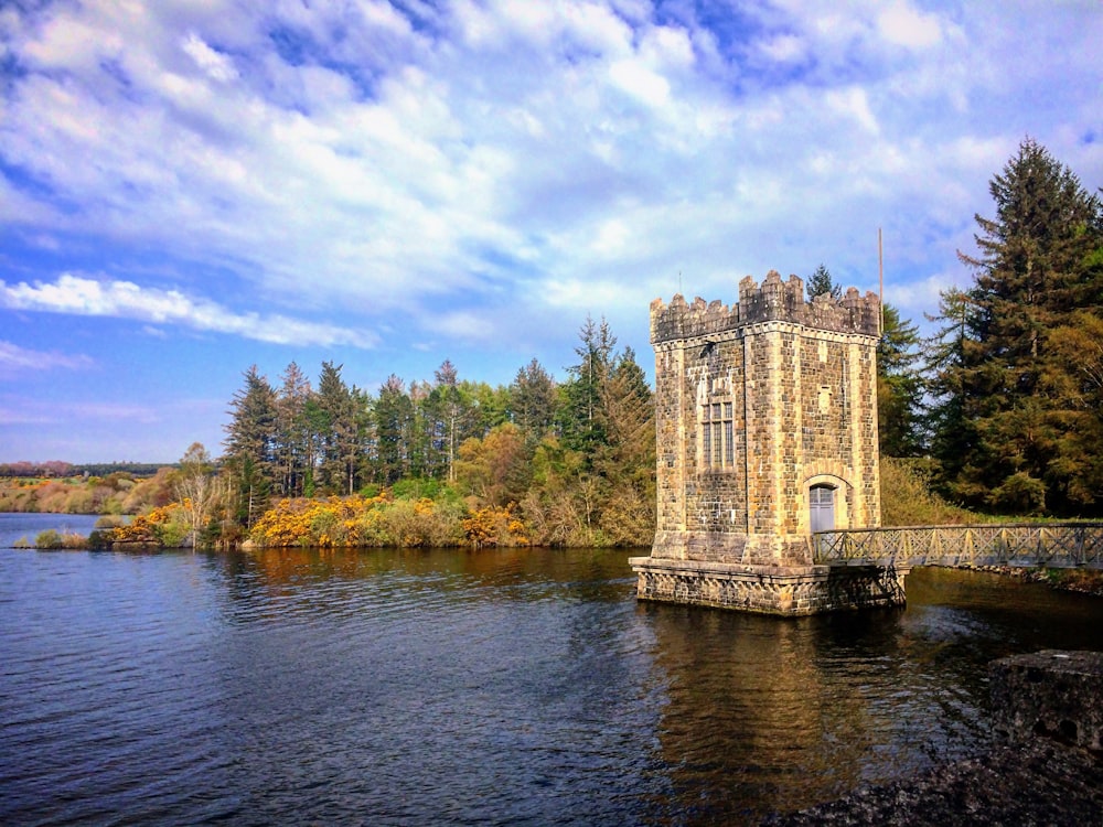 a castle sitting on top of a lake surrounded by trees