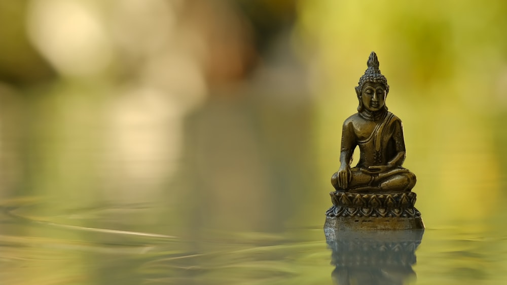 a small buddha statue sitting on top of a table