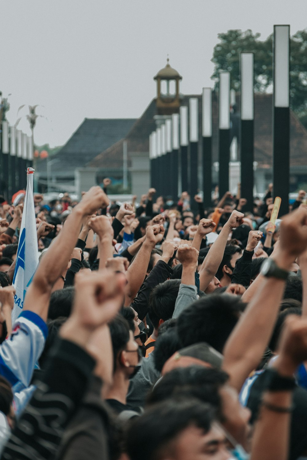 a crowd of people raising their hands in the air