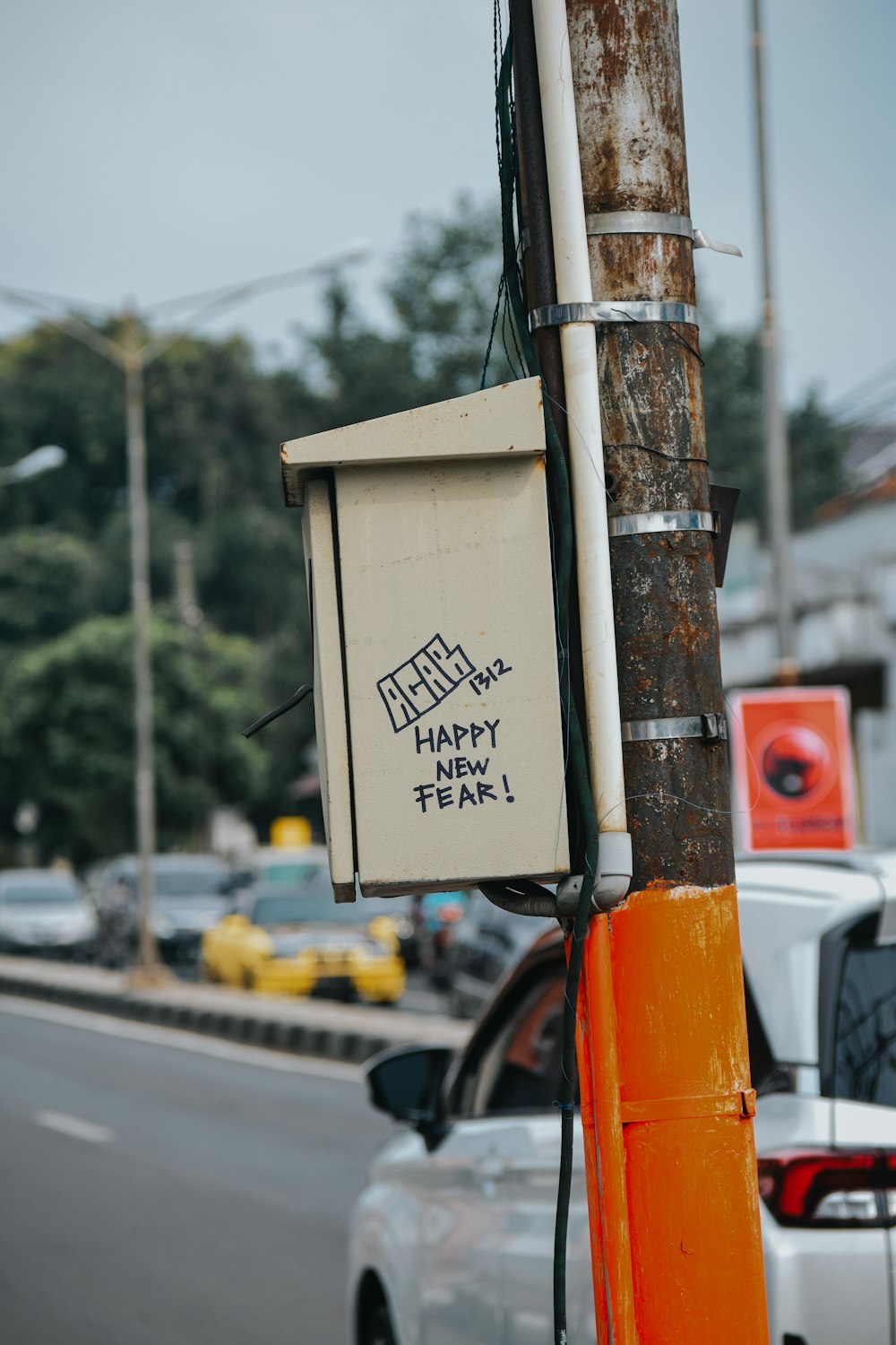 a street sign on a pole with a car in the background