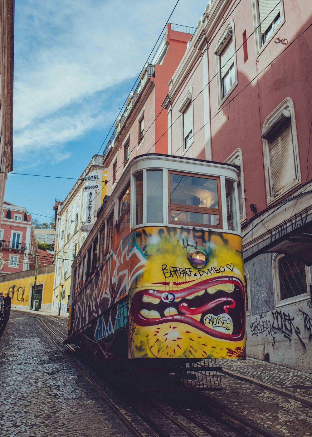 a trolley car with graffiti painted on the side of it