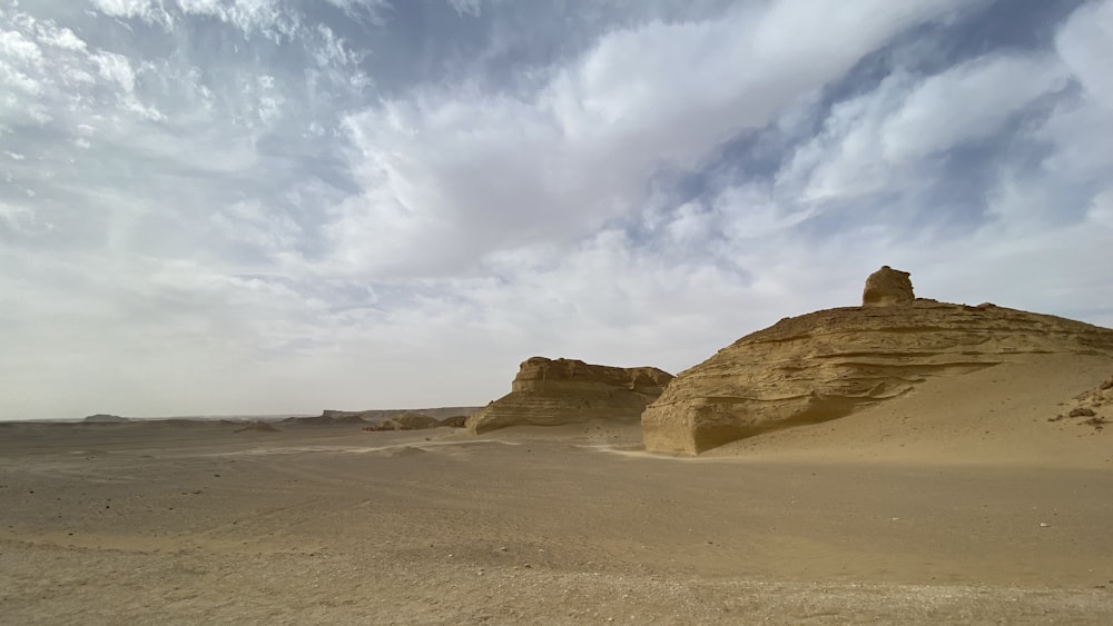 a desert landscape with a rock formation in the foreground