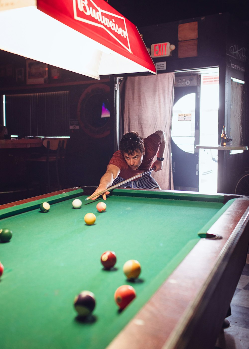 a man leaning over a pool table to hit a ball