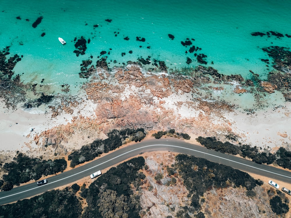 an aerial view of a road next to the ocean