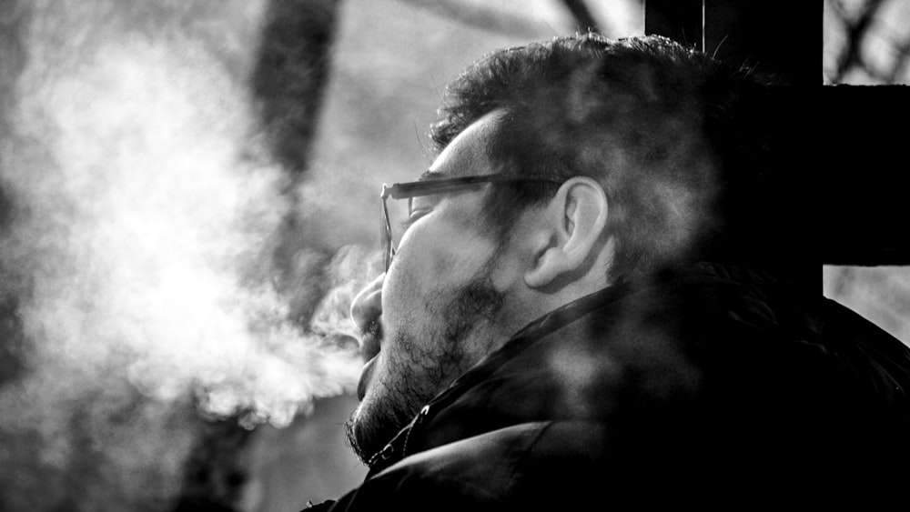 a man smoking a cigarette in a black and white photo