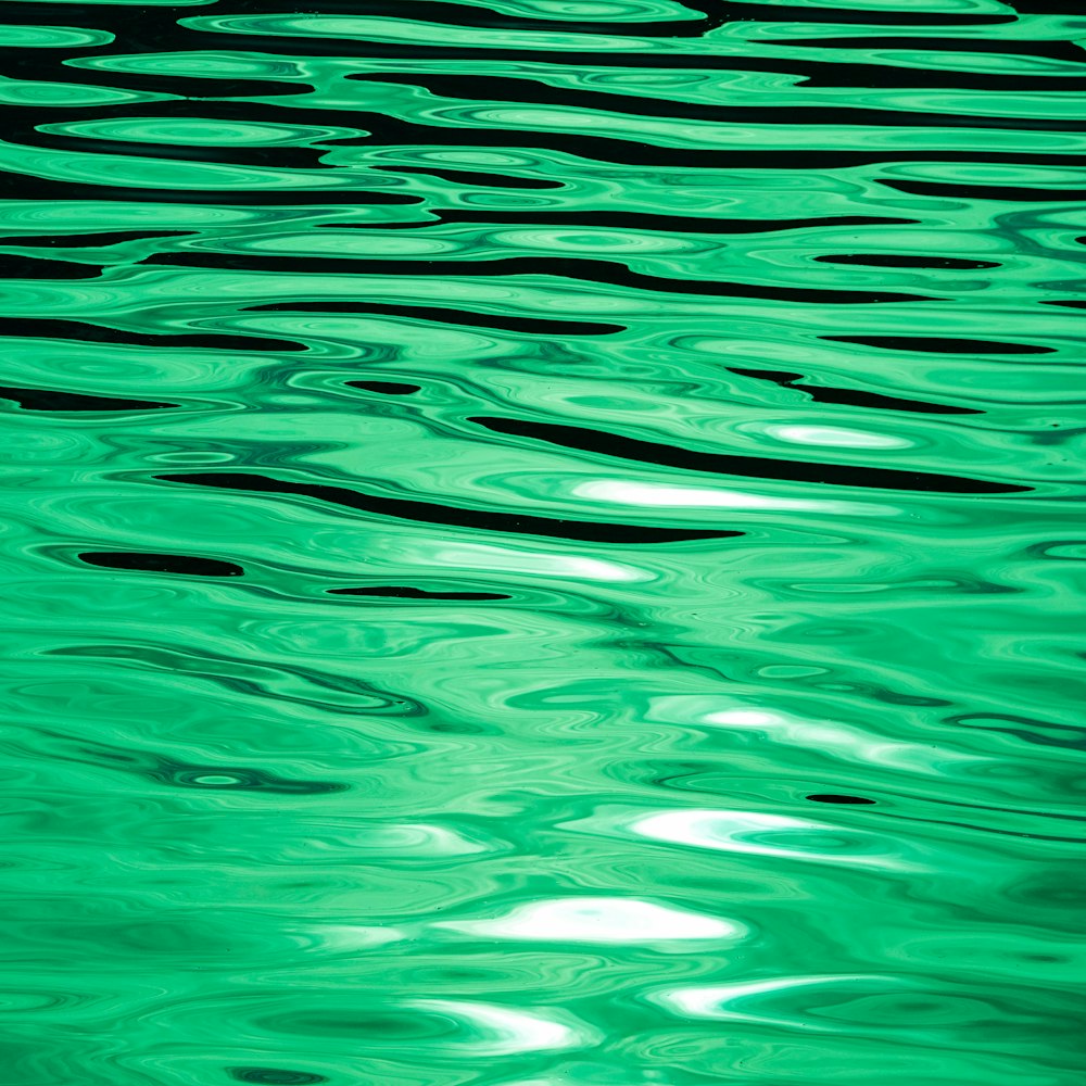 a large body of water with green reflections on it
