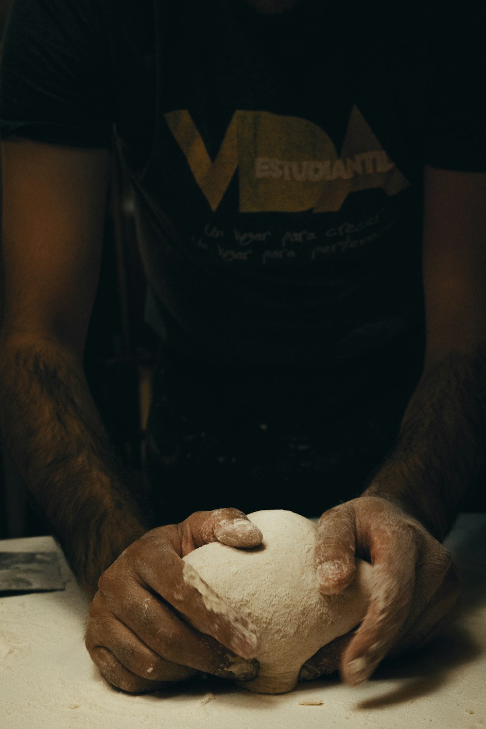 a man holding a ball of dough in his hands