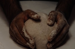 Close-up of hands kneading dough, symbolizing hands-on culinary training.