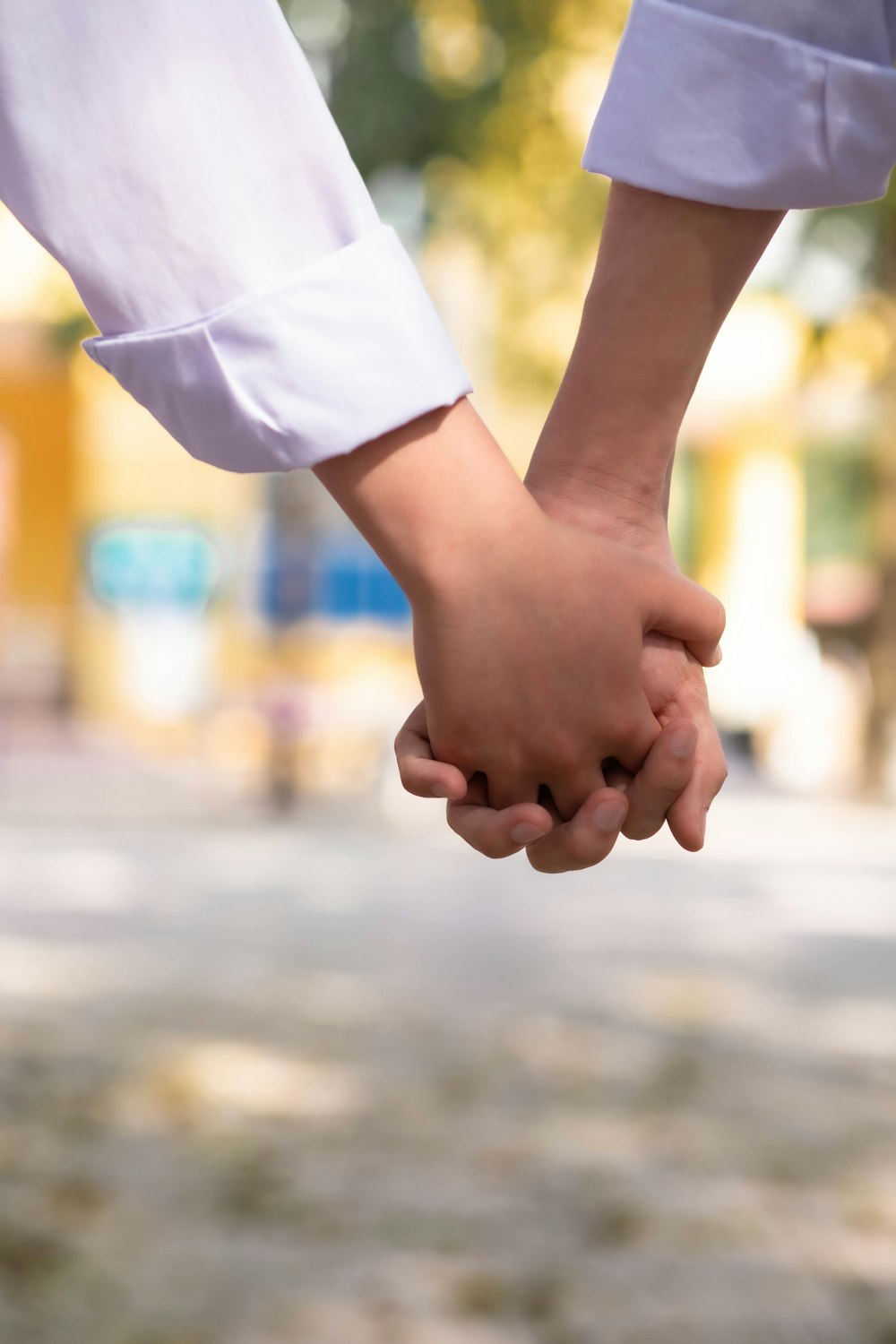 a close up of two people holding hands