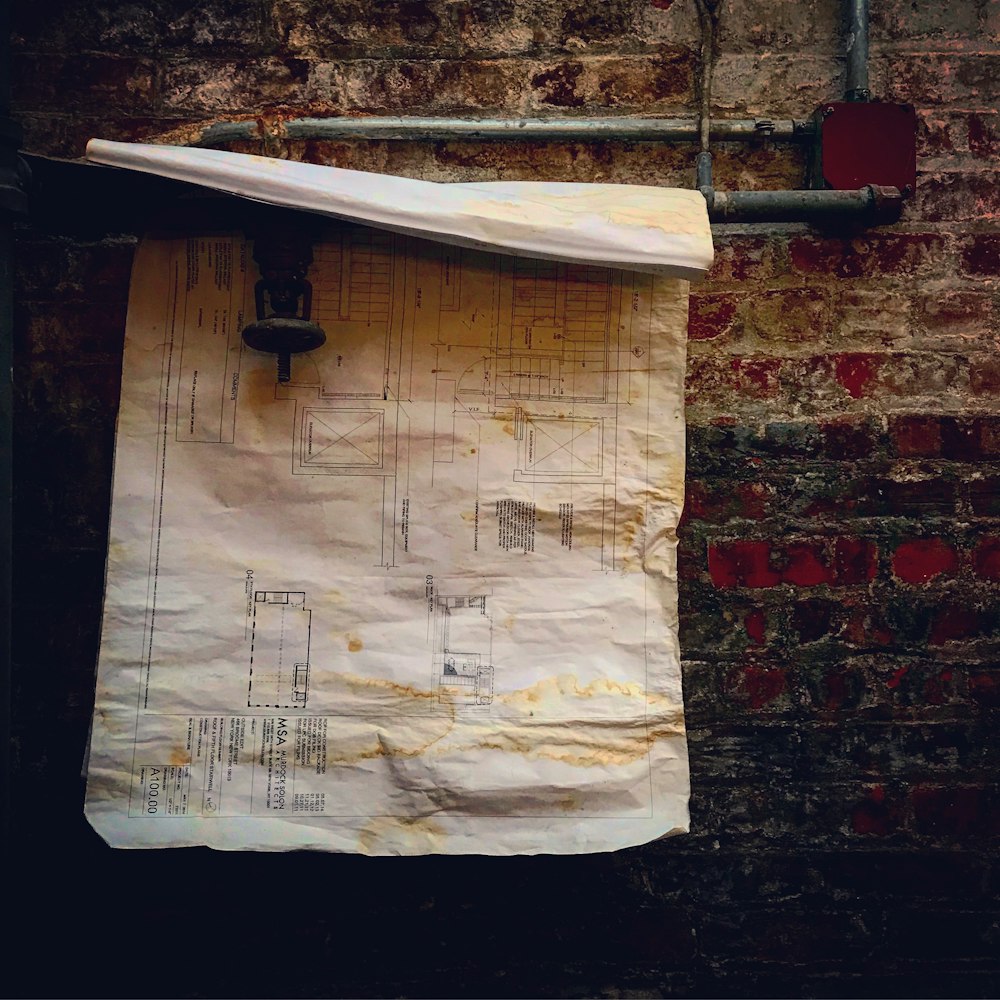 a piece of paper hanging on a brick wall