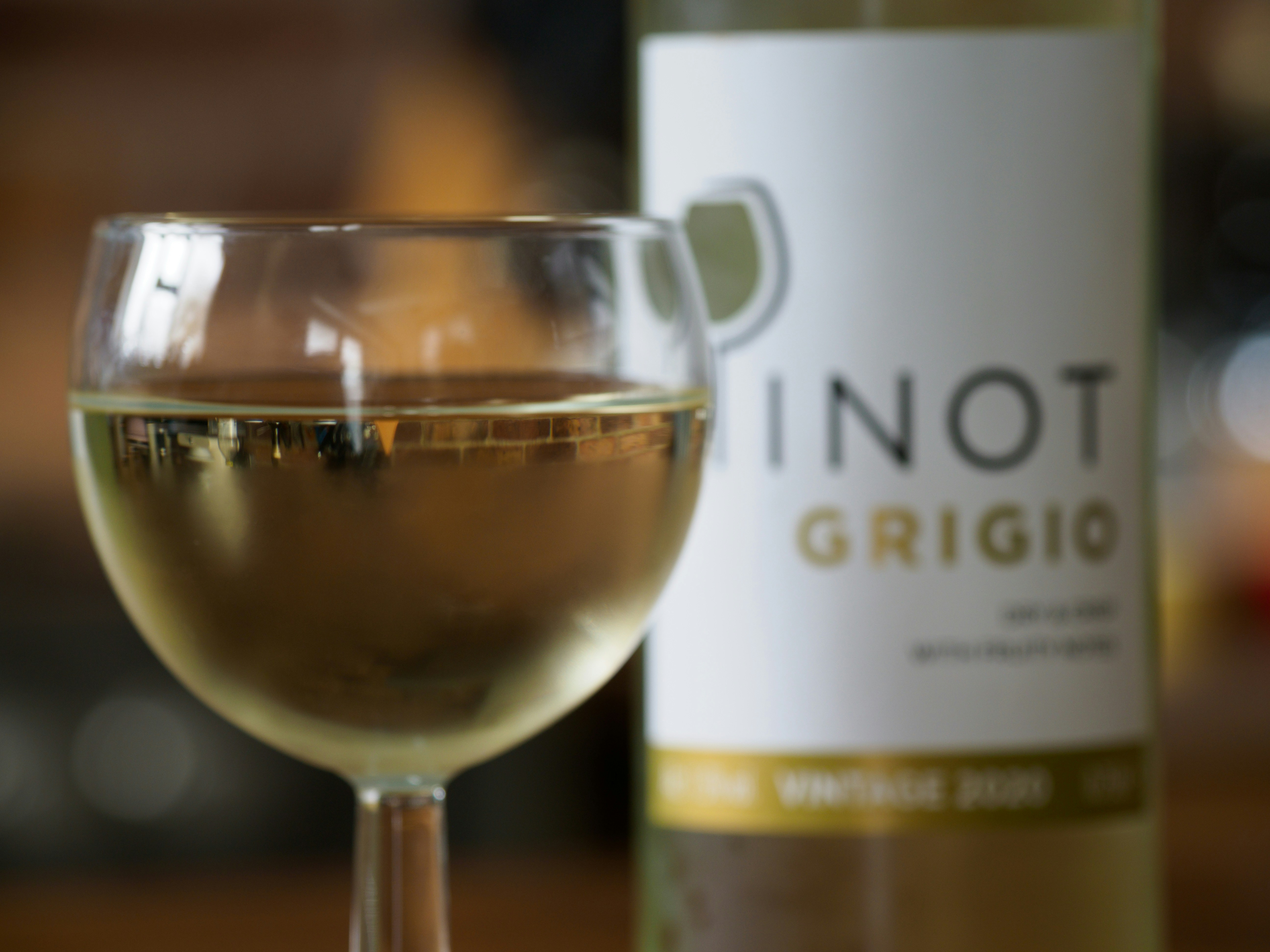 a glass of wine next to a bottle of wine