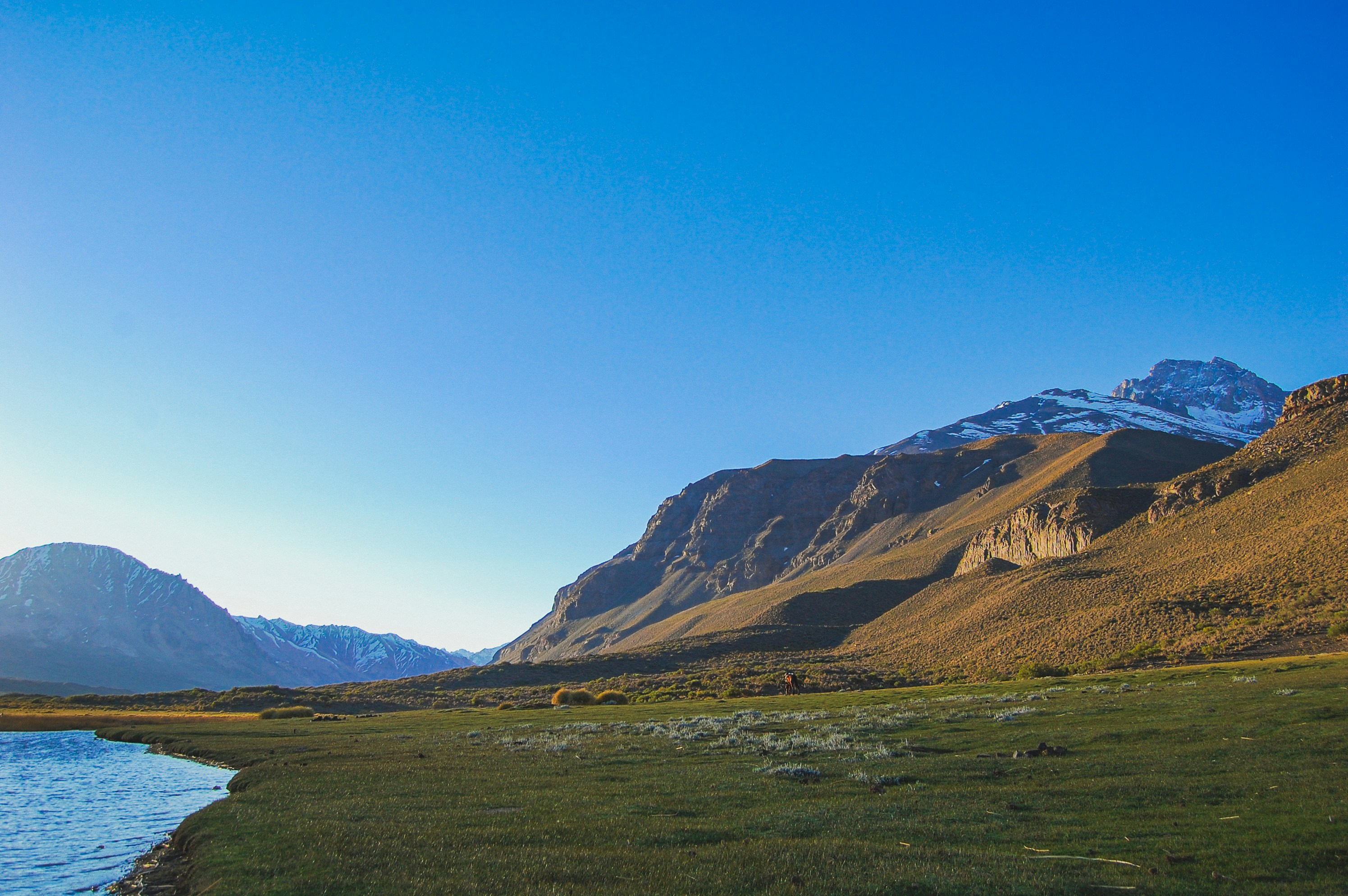 a mountain range with a body of water in the foreground