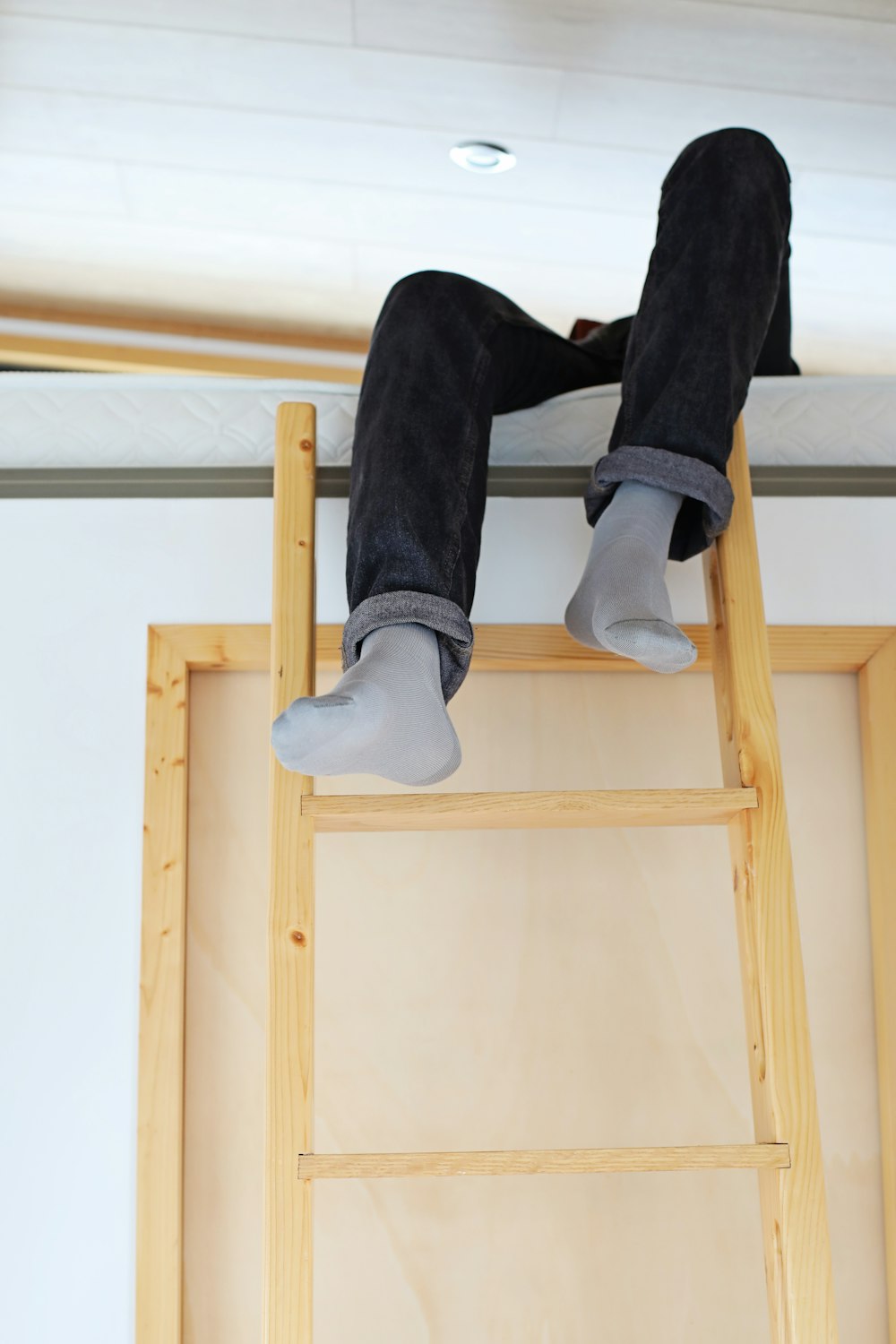 a person sitting on top of a wooden ladder