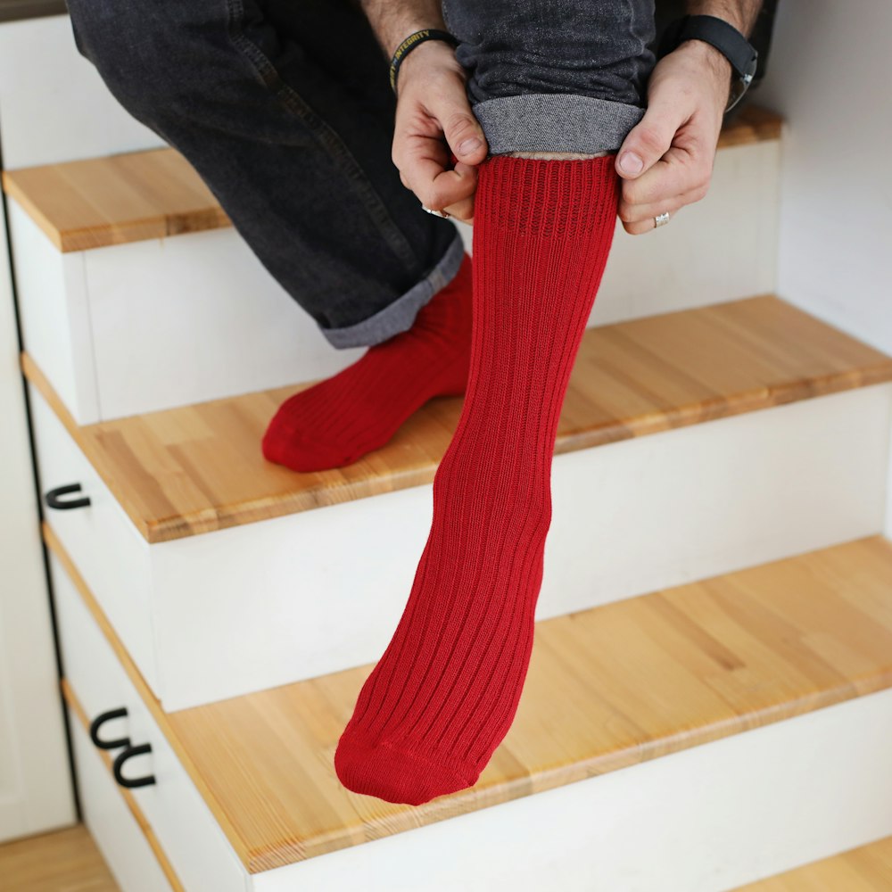 a person sitting on a set of stairs with red socks