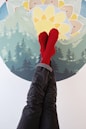 a person's feet with red socks and socks on