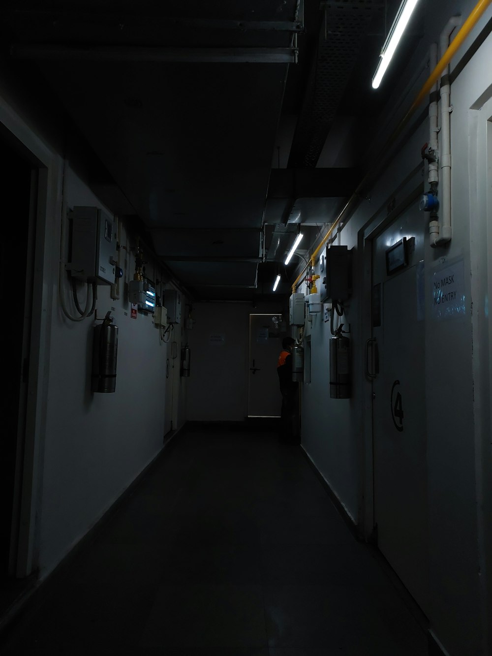 a dark hallway with electrical equipment on the walls