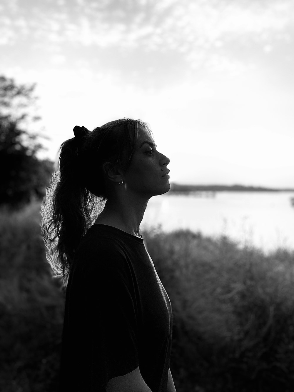 a woman standing in front of a body of water