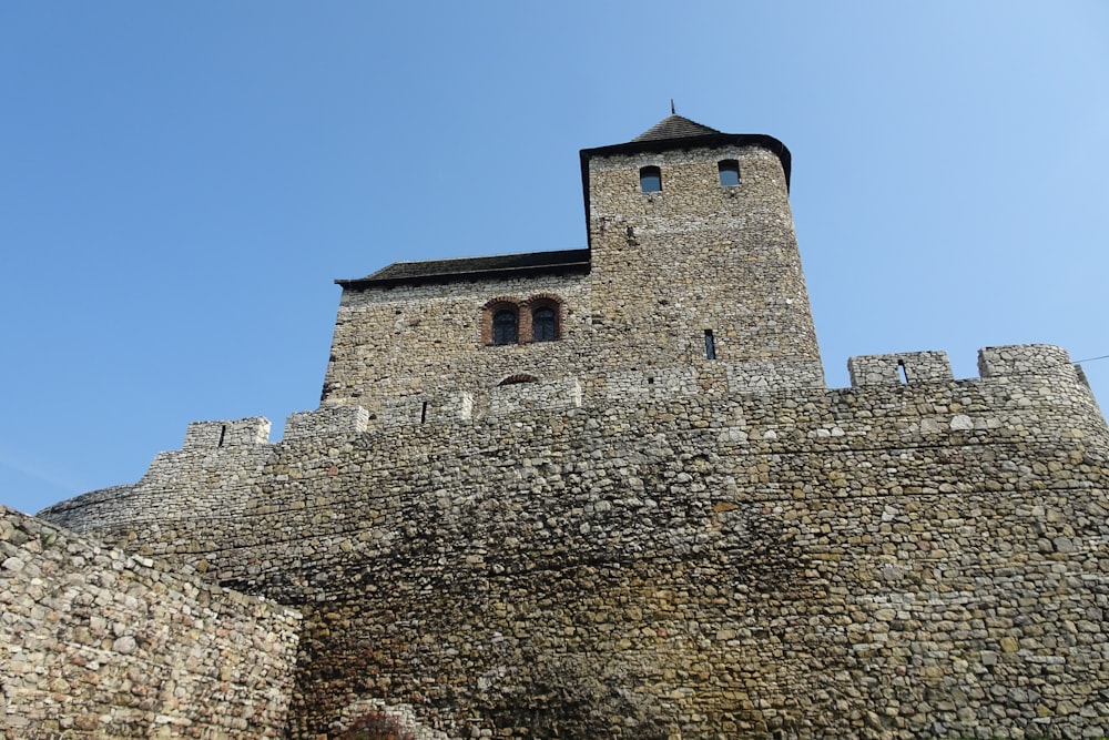 un muro de piedra con una torre del reloj en la parte superior