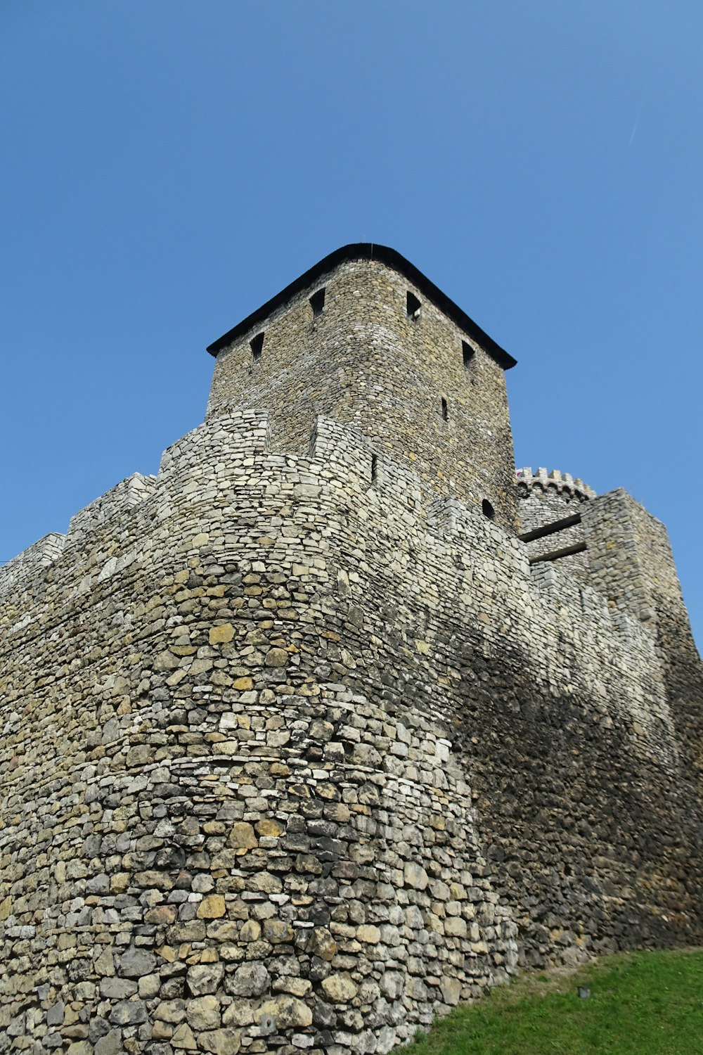 a very tall brick tower with a clock on it's side