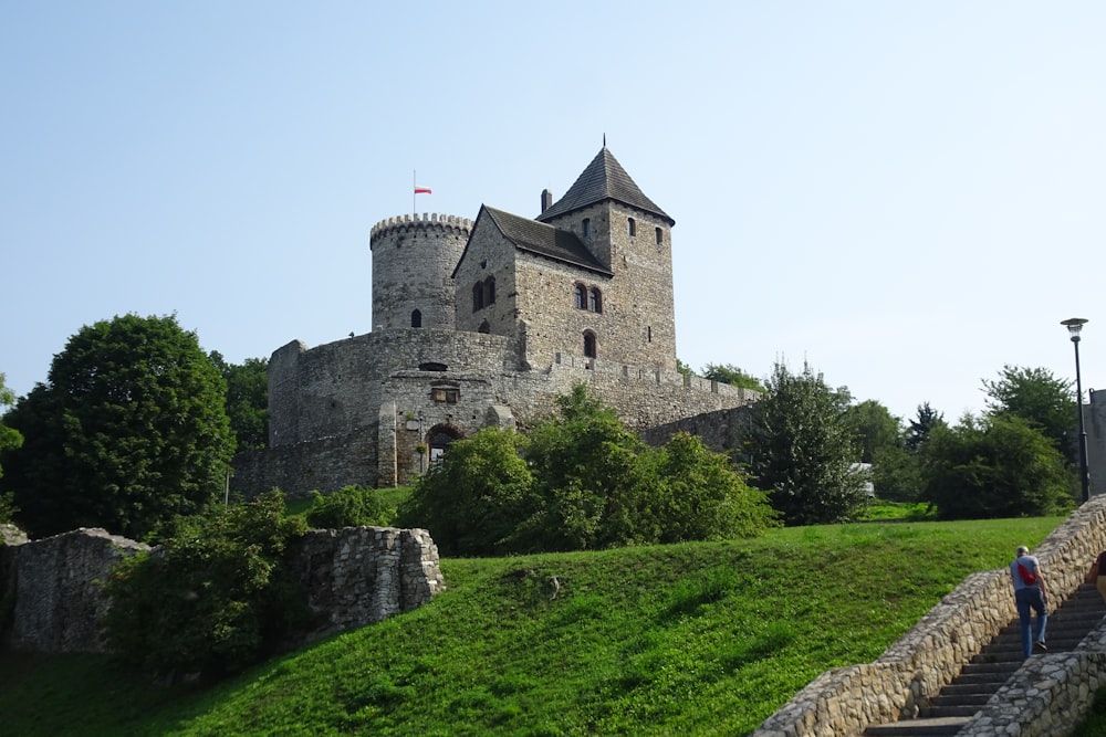 two people walking up a set of stairs to a castle