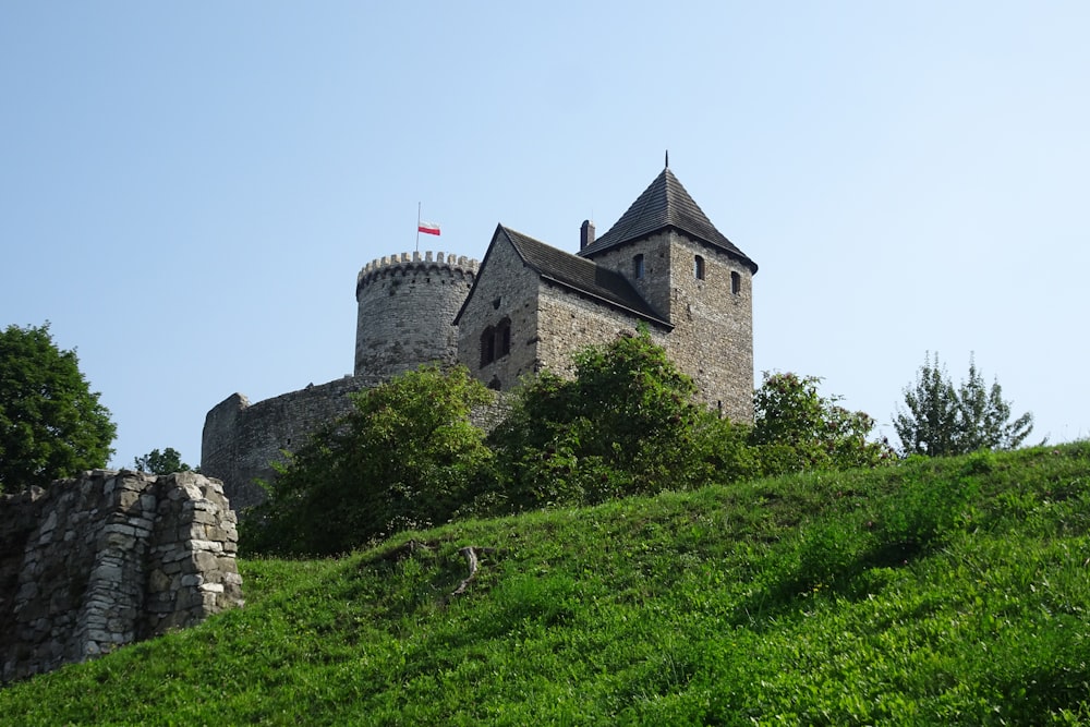 Un castillo en una colina con una bandera en la cima