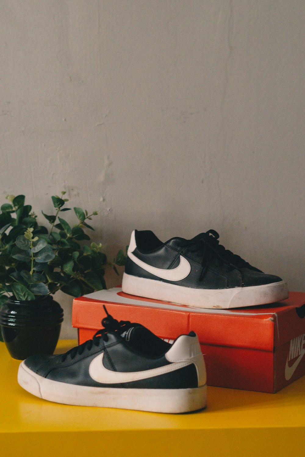 a pair of black and white sneakers sitting on top of a box