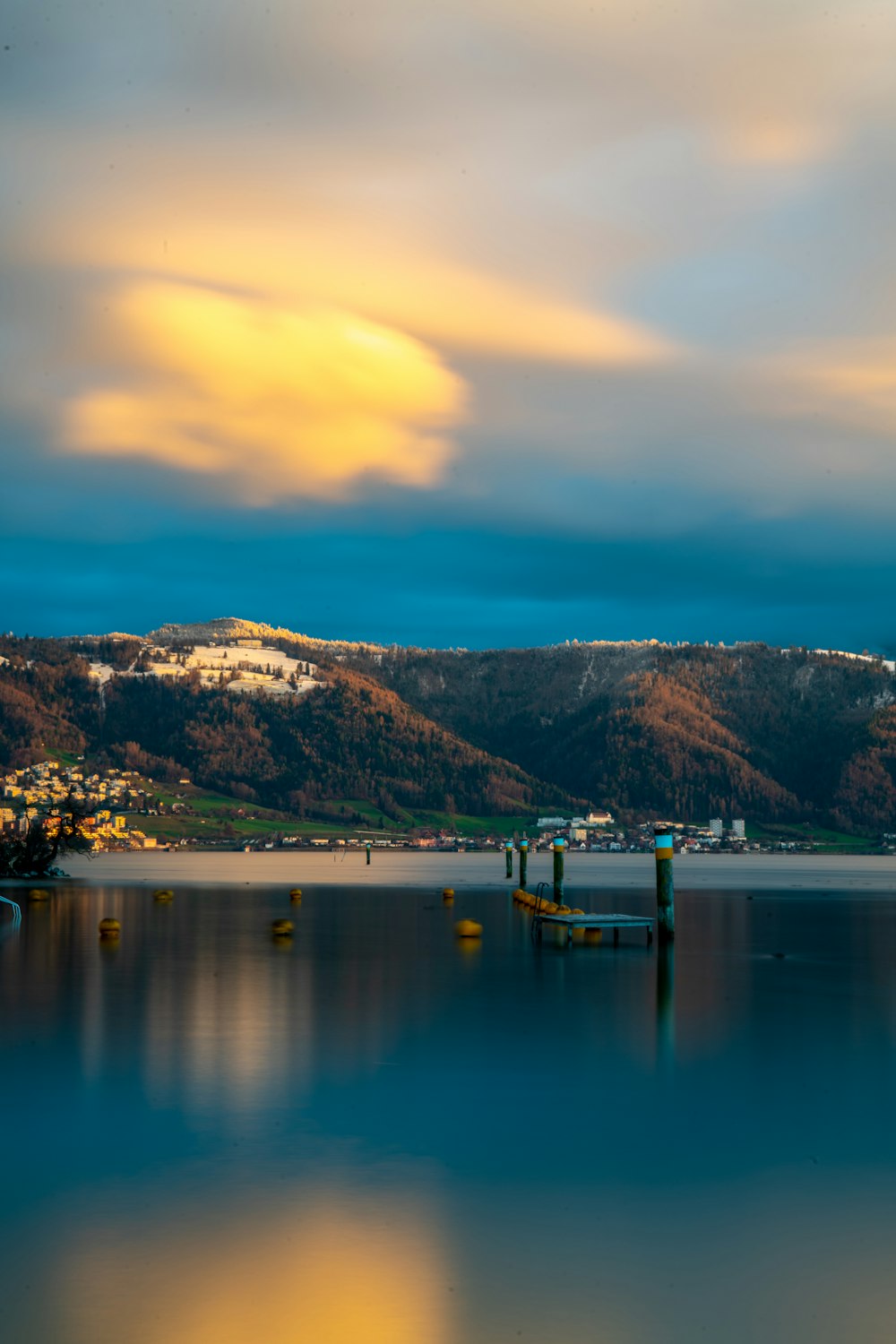 a body of water surrounded by mountains under a cloudy sky