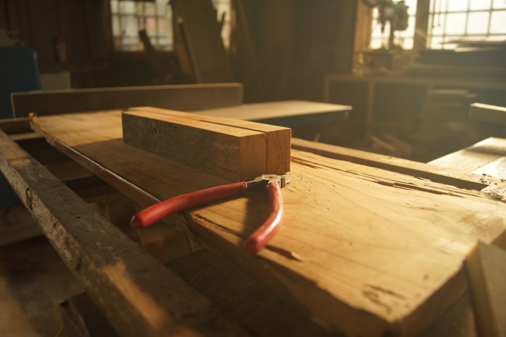 a piece of wood with a red handle on it